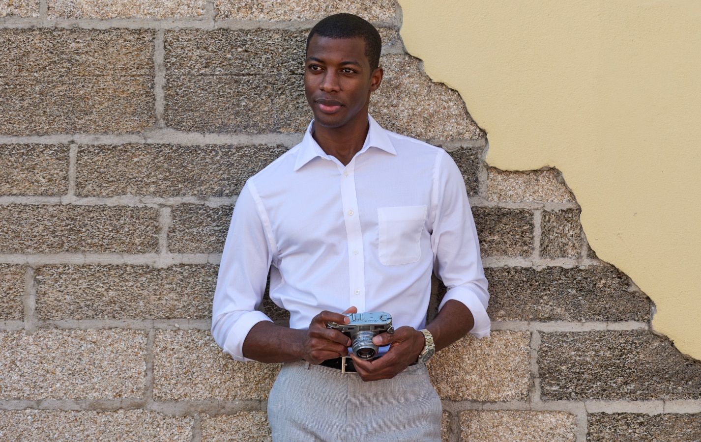 Man in white dress shirt holding a camera