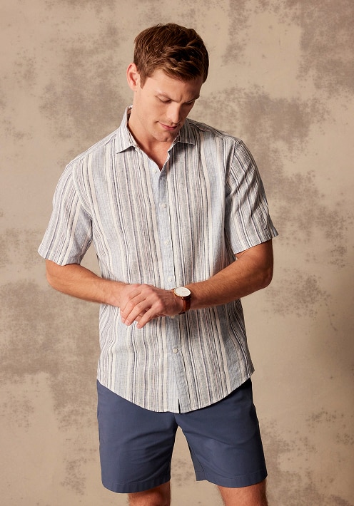 Man in a striped short-sleeve shirt and navy shorts