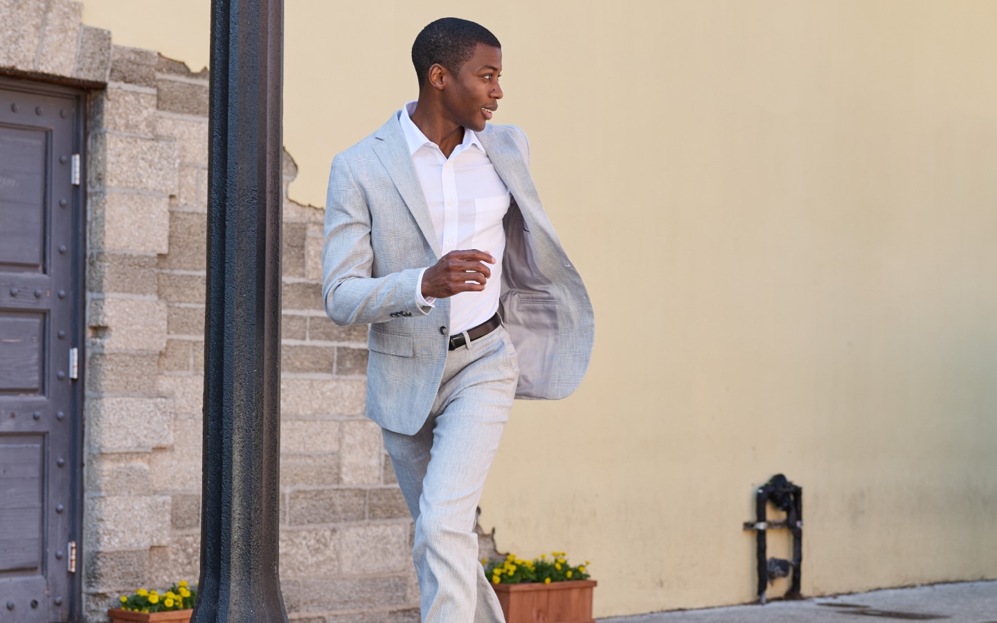 Man in a light grey suit and white dress shirt