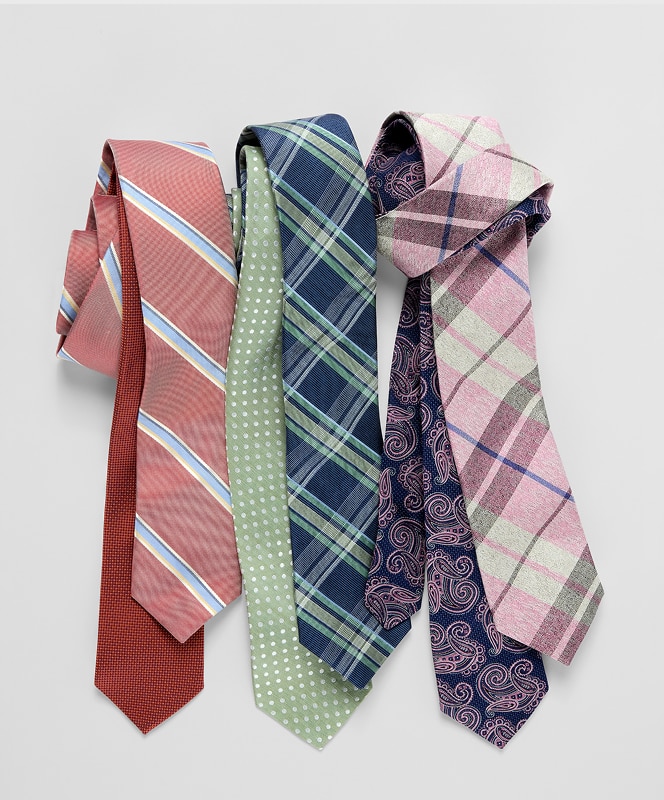 Five patterned mens neckties in red, green, navy, and pink