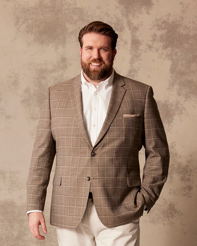 Man in a tan windowpane sportcoat and white dress shirt