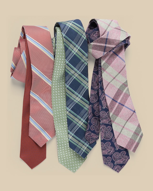 Collection of patterned mens neckties on a beige background