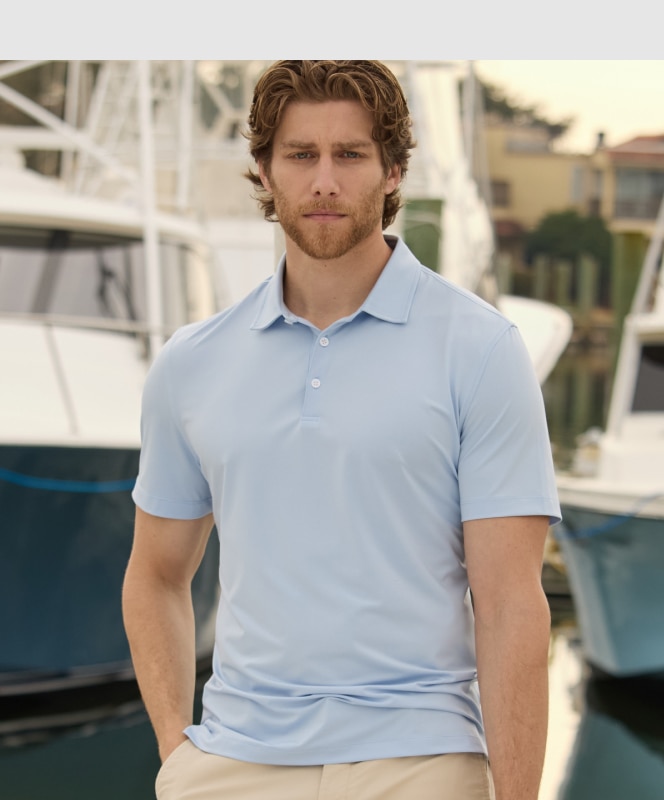 Man in a light blue polo shirt holding a rope on a boat