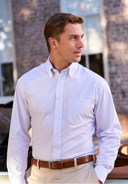 Man wearing a light blue button-down dress shirt with khaki pants and a brown leather belt