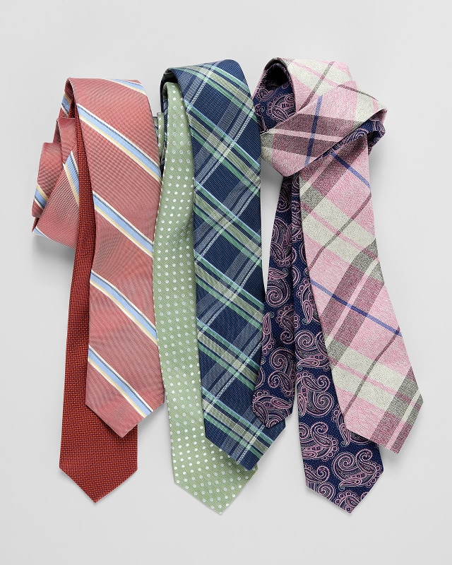 Assortment of patterned neckties including stripes, polka dots, plaid, and paisley