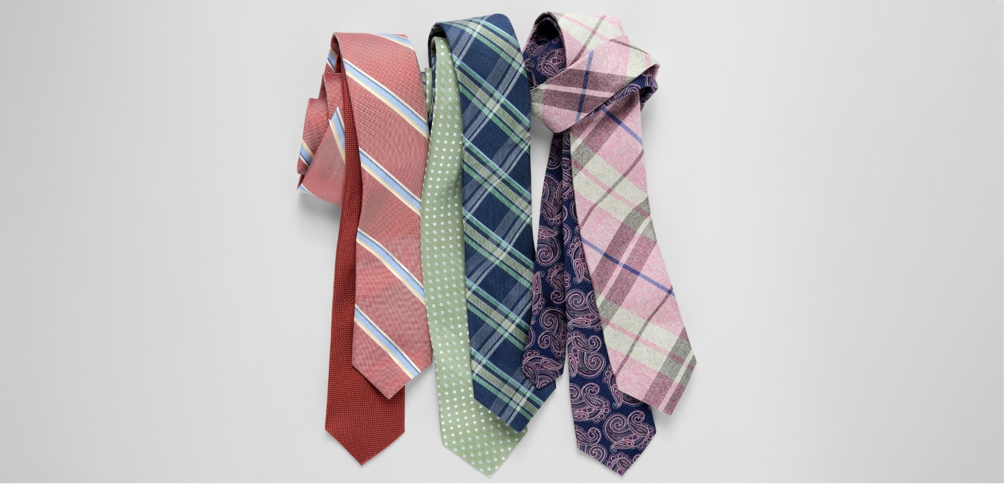 Collection of patterned neckties on a light gray background
