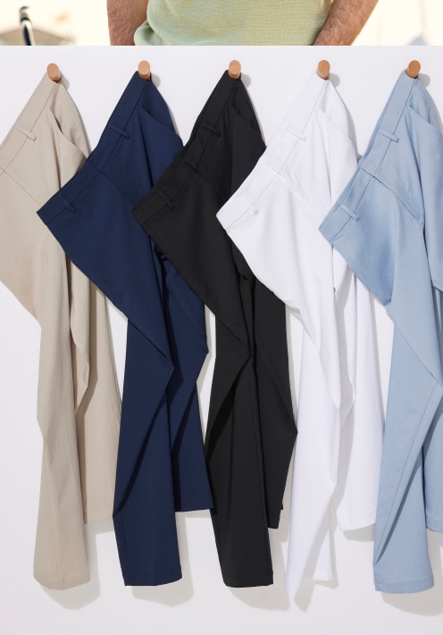 Five pairs of casual pants in khaki, navy, black, white, and light blue hanging on wooden pegs