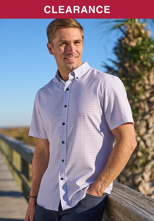 Man wearing a patterned short-sleeve casual shirt on a sunny boardwalk