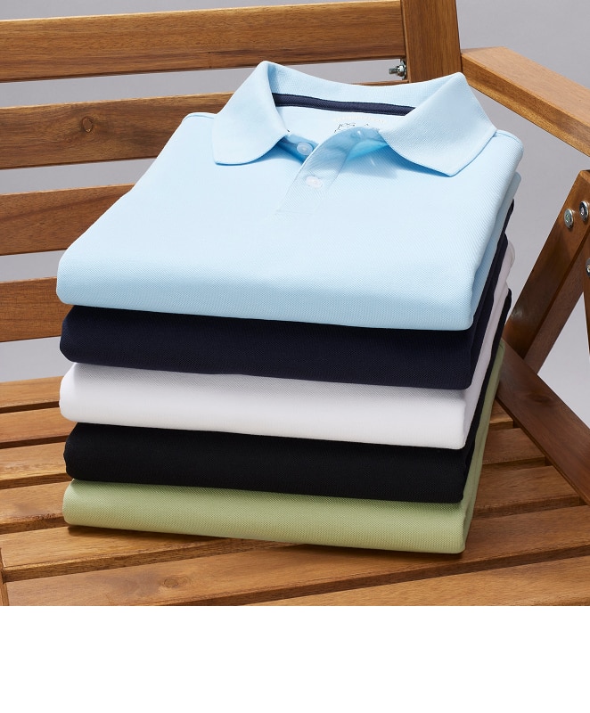 Stack of folded polo shirts on a wooden bench