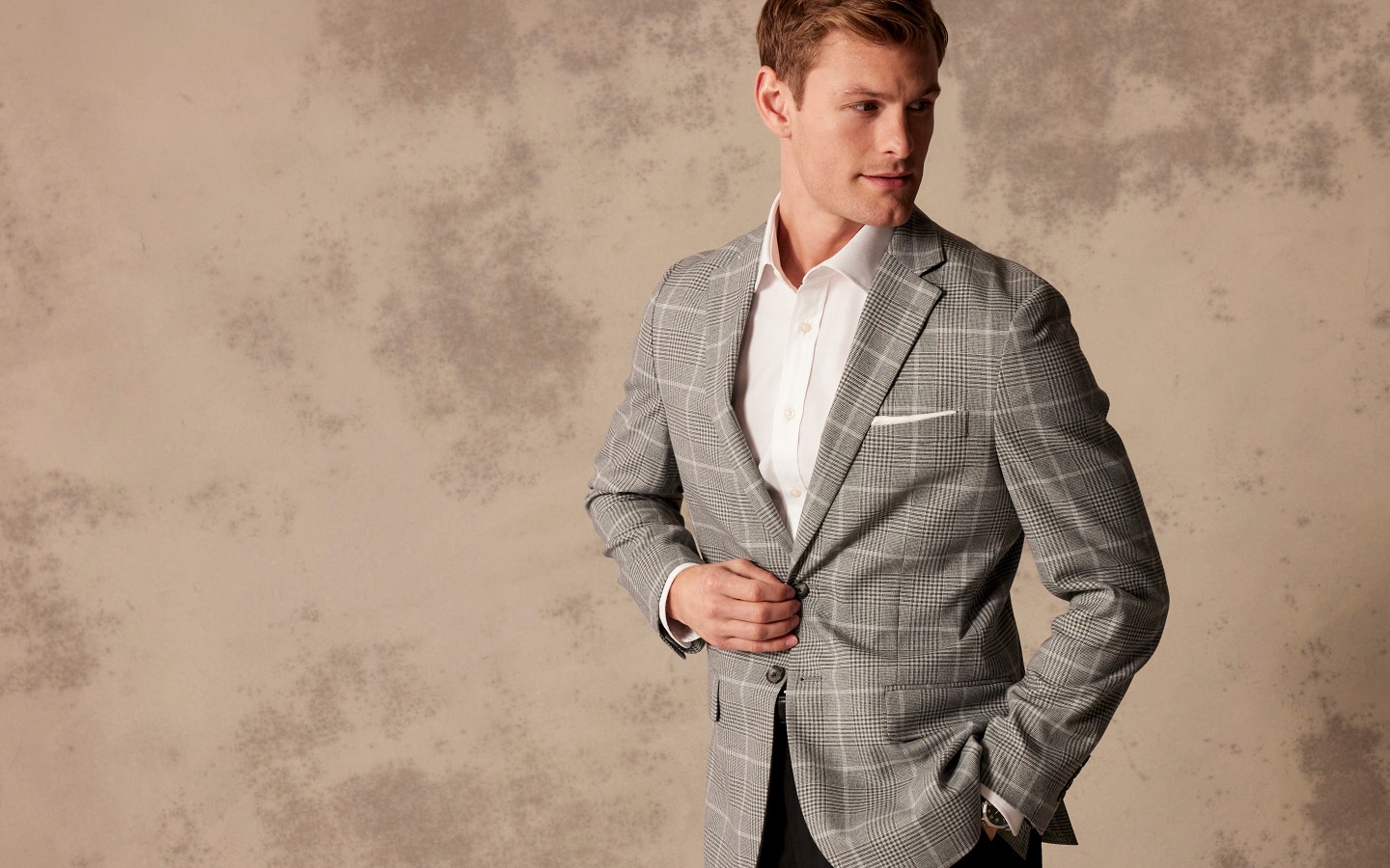 Man wearing a grey plaid sportcoat over a white dress shirt