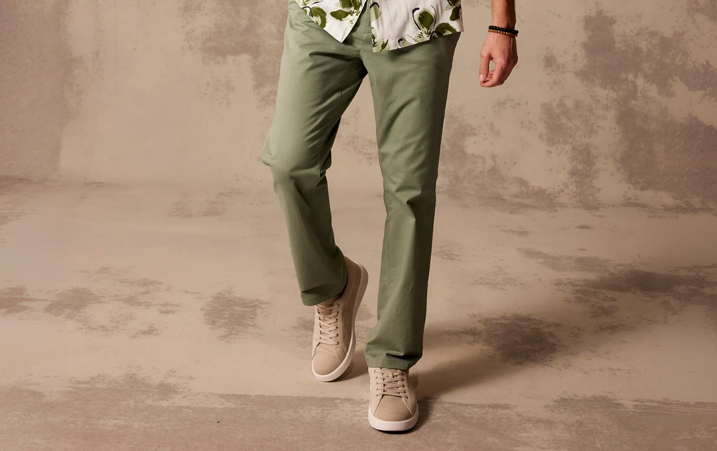 Person wearing olive green chinos and tan sneakers
