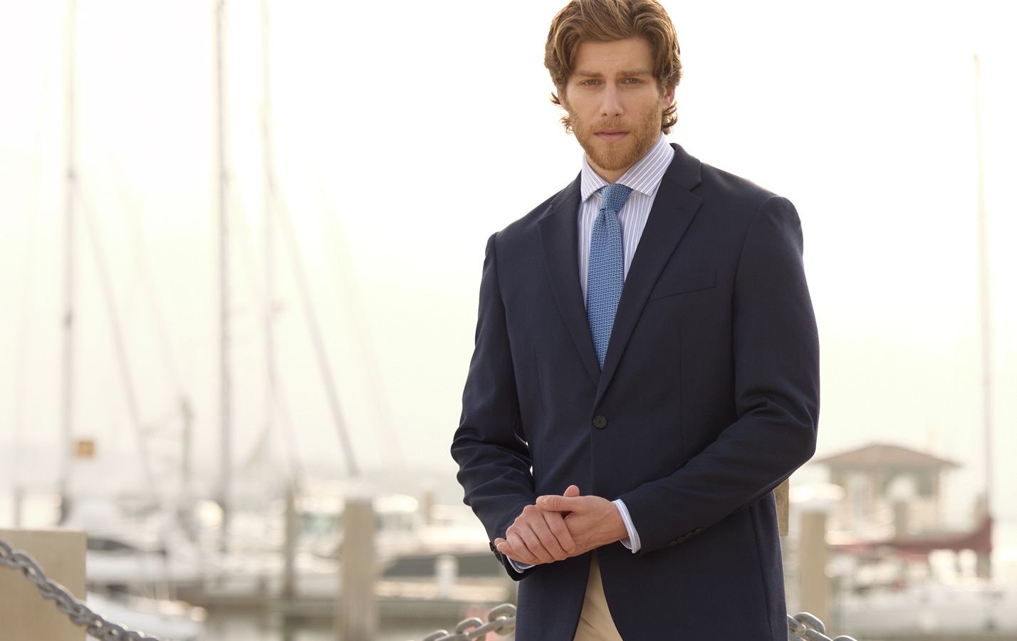 Man in a navy double-breasted blazer with gold buttons