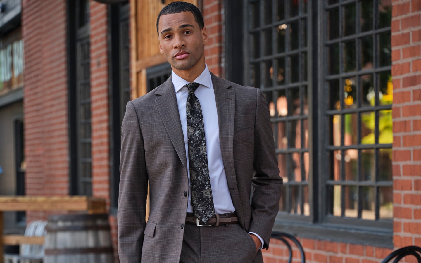 Man wearing a patterned suit, light blue dress shirt, and dark patterned tie