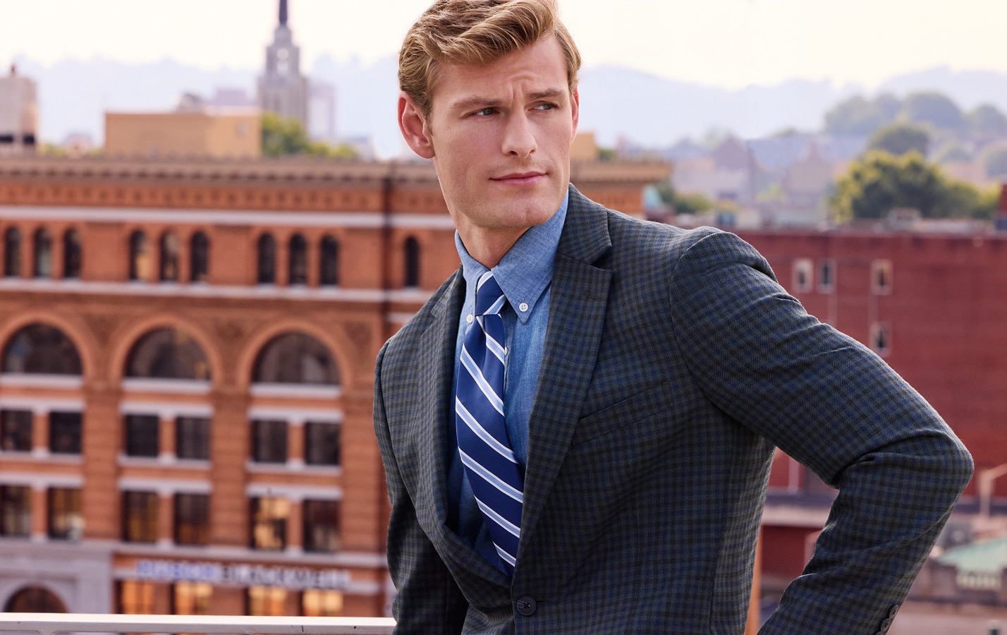 Man wearing a charcoal sportcoat, light blue shirt, and striped tie