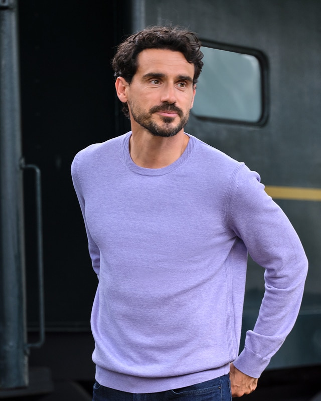 Man wearing a lavender crew neck sweater