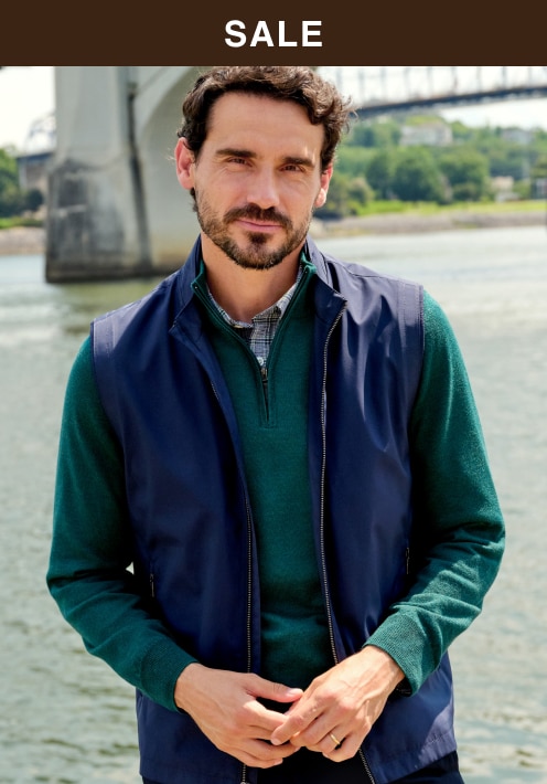 Sale. Man wearing a navy sportcoat over a green sweater