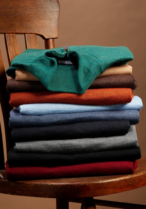 Stack of folded sweaters in assorted colors