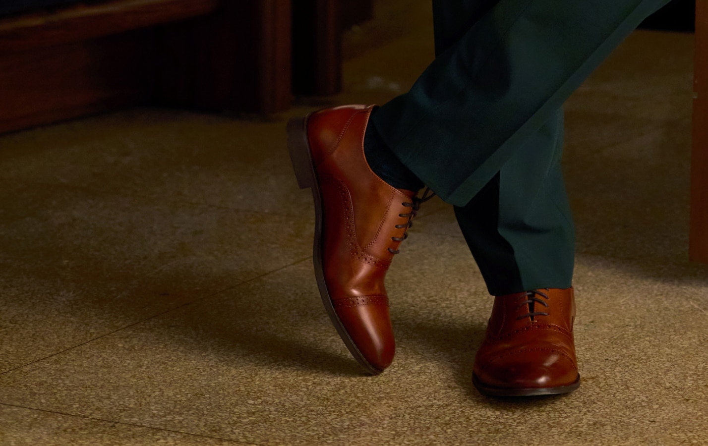 Brown dress shoes worn with a dark suit